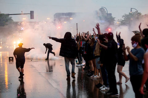 Protestors can be seen against the night sky in a face-off with police officers