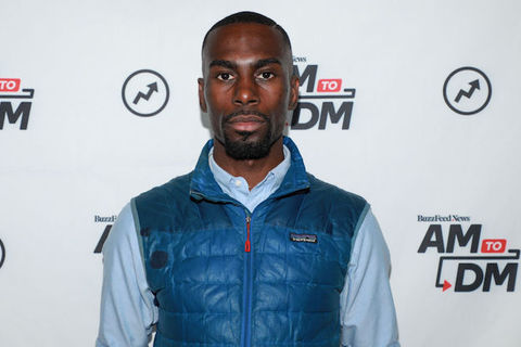 Close up shot of Black man wearing a blue vest