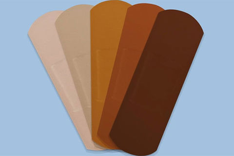 Band Aid. Five bandage strips ranging in color from light tan to dark brown.