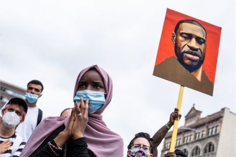 George Floyd Protest. Black Muslima with purple chador, facemask, and others with photo of Geroge Floyd