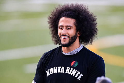 Colin Kaepernick. Black man with Afro wearing black Tee reading "Kunta Kinte" over a gray Tee.