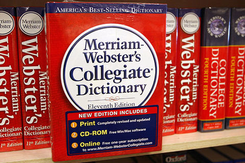 Merriam-Webster dictionary. A line of books on a shelf.