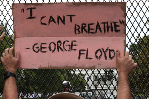 A protestor outside of the White House holds a sign that reads, "I Can't Breathe"