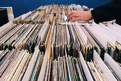 Records. Hand sifting through rows of vinyl records.