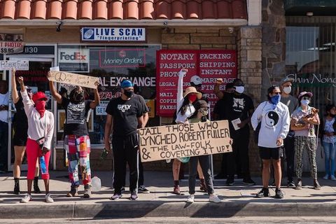 group of protestors holding signs demanding justice for Robert Fuller