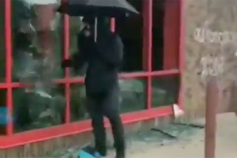 Umbrella Man. Man carrying a black umbrella dressed in all black on the street.