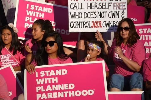 Group of women holding pink signs in support of Planned Parenthood