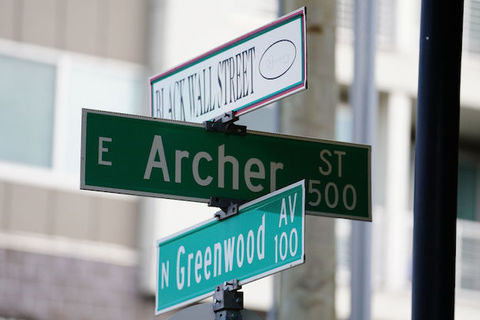 Tulsa street signs that read Black Walk Street, Archer and Greenwood