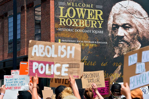 Abolish- police.Douglass. Photo of Federick Douglass behind a protest sign reading Abolish Police. 