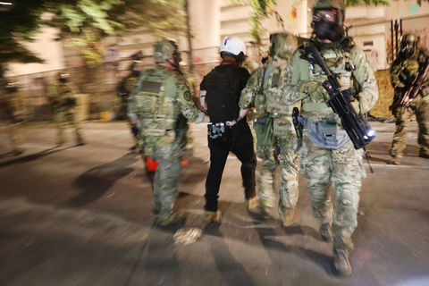 federal agents in riot gear arrest a citizen and walk away from the camera, 