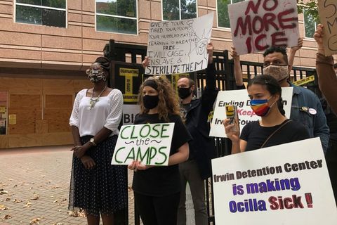 A small multi-racial group of protesters gathers during a press conference about questionable hysterectomies on women in ICE custody.