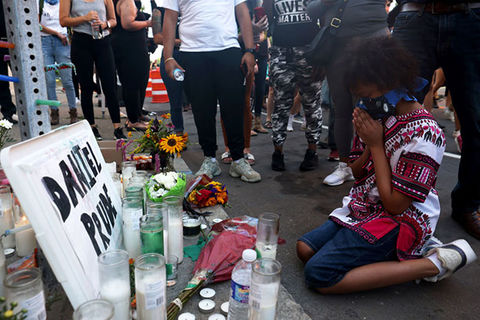Daniel Prude. Young Black boy prayers on his knees on the ground at a makeshift memorial for Daniel Prude.
