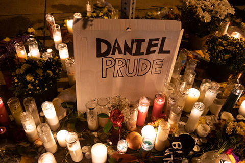 Daniel-Prude-Memorial. Sign reading "Daniel Prude" surrounded by lit candles and flowers.