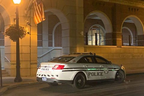 Police cruiser. White car with blue letters.