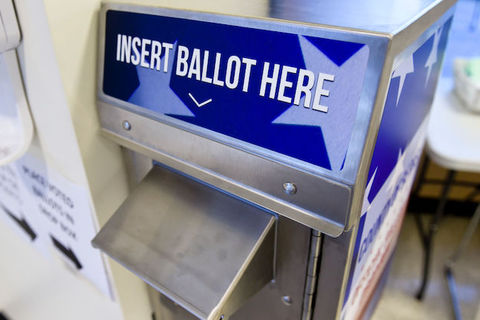 a blue and silver mailbox has Insert Ballot Here written on the top. 