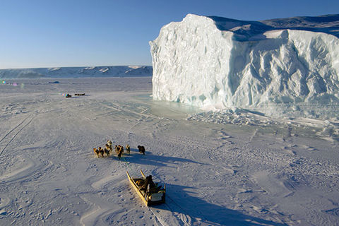 The Last Ice. Two dogsleds travel over sea ice and passed an iceberg.