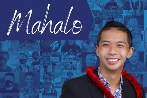 Adrian Tam. Asian American man with short dark hair wearing a blue shirt and dark suit jacket and red lei. 
