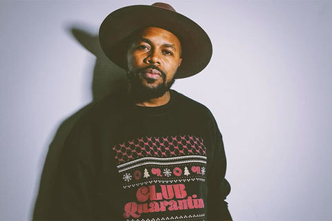 D-Nice. Black man wearing large-brimmed brown hat wearing a black sweatshirt reading "Club Quarantine."