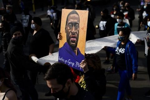 A crowd holds a casket and roses in effigy to George Floyd, who was killed by Minneapolis police in Summer 2020.
