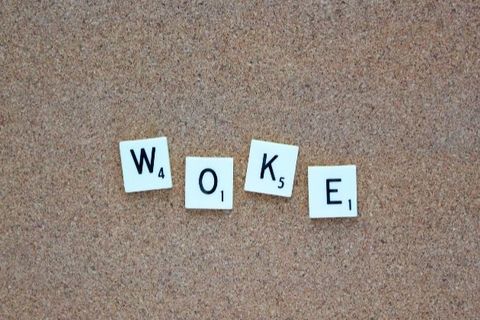 White letters spelling out the word "woke" in black text