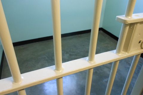 Yellow-painted prison bars, blue walls, gray floors.